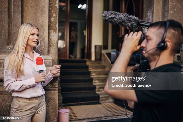 tv reporter in front of the camera reporting news - tv reporter stock pictures, royalty-free photos & images