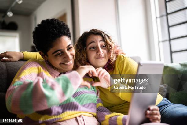 female friends filming or on a video call on a digital tablet at home - generation z covid stock pictures, royalty-free photos & images