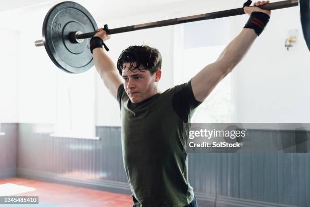 pushing himself to achieve fitness goals - weight training stock pictures, royalty-free photos & images