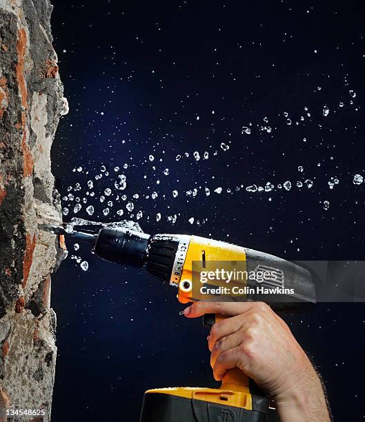 drilling into wall with water leak - drill stockfoto's en -beelden