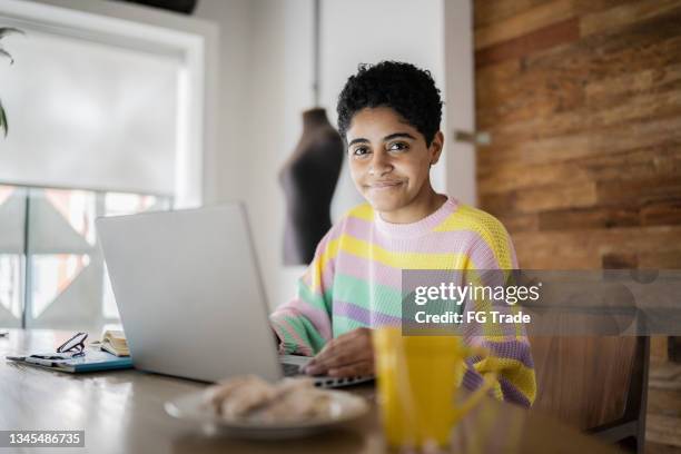 porträt einer jungen frau mit einem laptop zu hause - alternative lifestyles stock-fotos und bilder