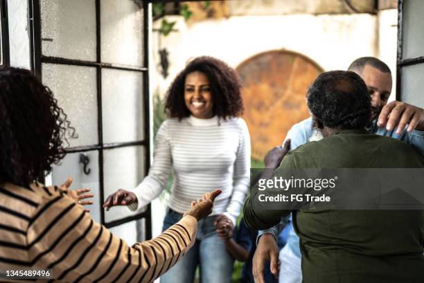 family members greeting each other at home - black family reunion stock pictures, royalty-free photos & images