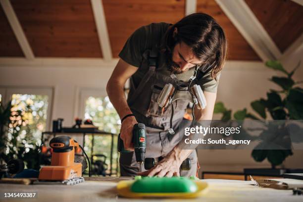 male skater fixing a skateboard - handy 個照片及圖片檔