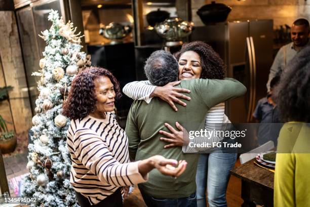 woman embracing father on christmas time at home - christmas guest stock pictures, royalty-free photos & images