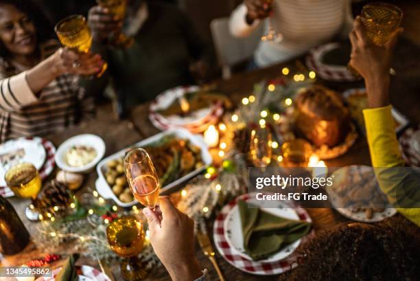 familienanstoßen auf weihnachtsliches abendessen zu hause - christmas dinner stock-fotos und bilder