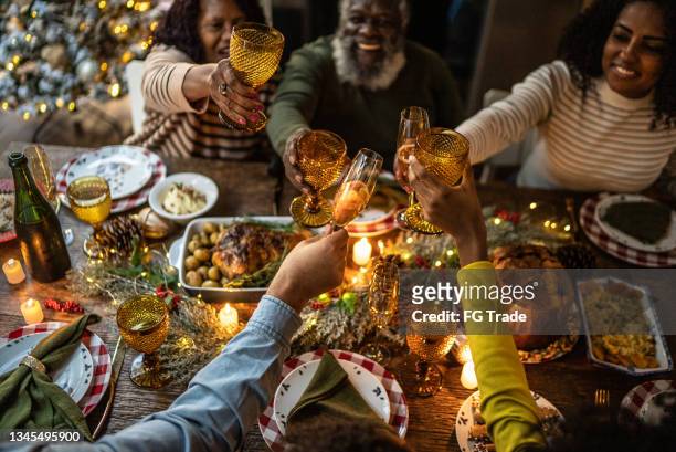 family toasting on christmas dinner at home - nationale feestdag stockfoto's en -beelden