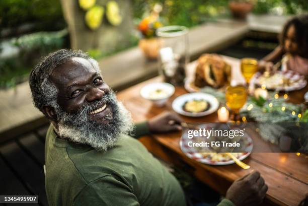 porträt eines glücklichen älteren mannes zu weihnachten zu hause - african american christmas images stock-fotos und bilder