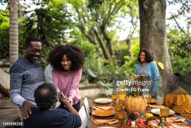 family or friends greeting each other on thanksgiving at home - thanksgiving arrival stock pictures, royalty-free photos & images