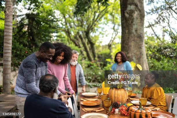 family or friends greeting each other on thanksgiving at home - thanksgiving arrival stock pictures, royalty-free photos & images