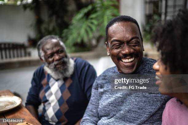 happy family reunited on the table at home - multi generation family candid stock pictures, royalty-free photos & images