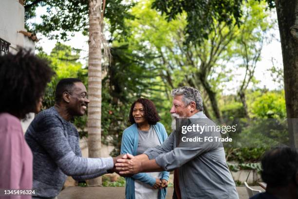 neighbors greeting each other at front house - local community stockfoto's en -beelden