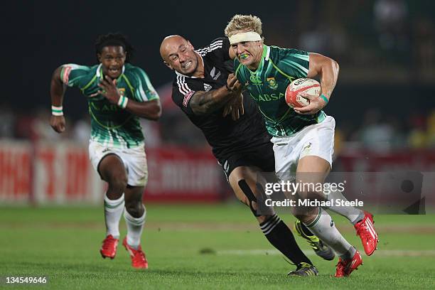 Kyle Brown of South Africa powers his way past DJ Forbes of New Zealand during the South Africa v New Zealand match on Day Two of the IRB Dubai...