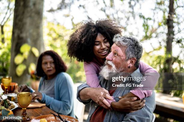 granddaughter hugging her grandfather on lunch time at home - vitiligo stock pictures, royalty-free photos & images