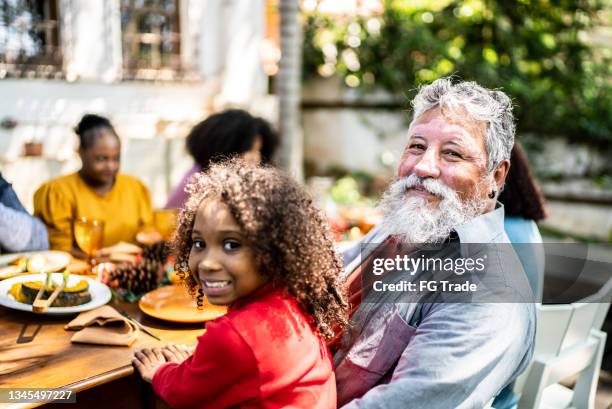 portrait of a grandfather and granddaughter on the table at home - buren stockfoto's en -beelden