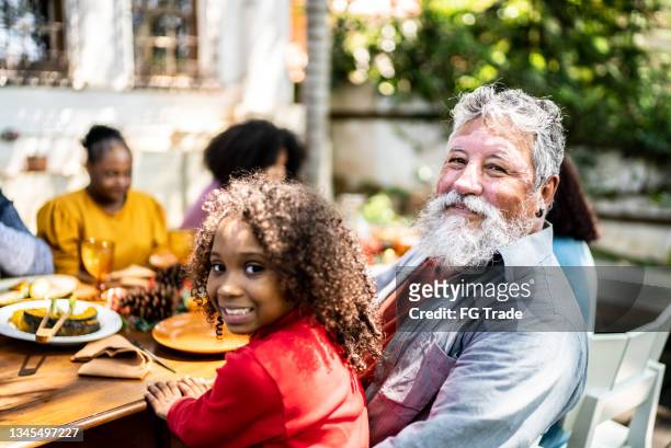 portrait of a grandfather and granddaughter on the table at home - neighbour stock pictures, royalty-free photos & images