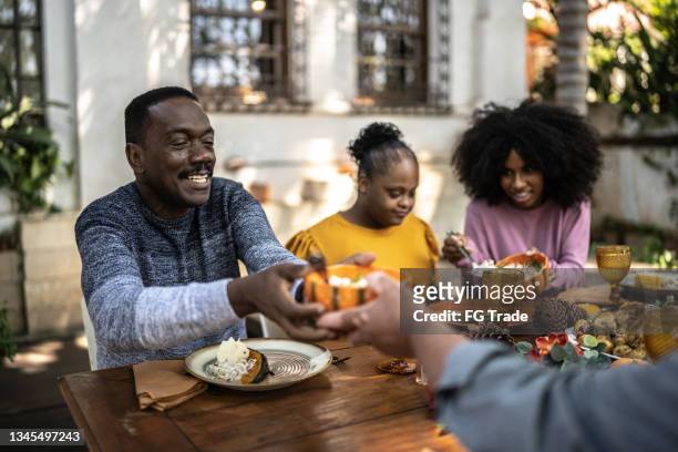 family eating on thanksgiving lunch at home - including special needs woman - november 22 stock pictures, royalty-free photos & images