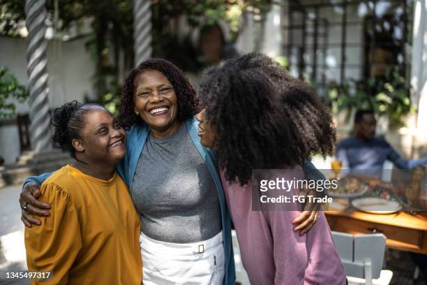 portrait of a mother with her daughters at home - woman with special needs - reünie sociaal stockfoto's en -beelden