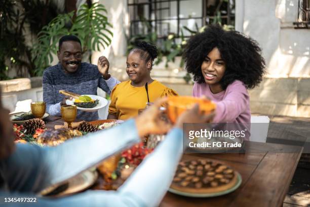 family eating on thanksgiving lunch at home - including special needs woman - man eating pie stock pictures, royalty-free photos & images