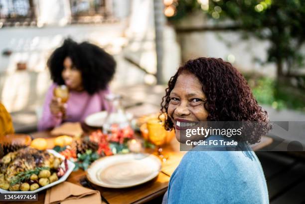 portrait of a senior woman on the table at home - african at dining table stockfoto's en -beelden