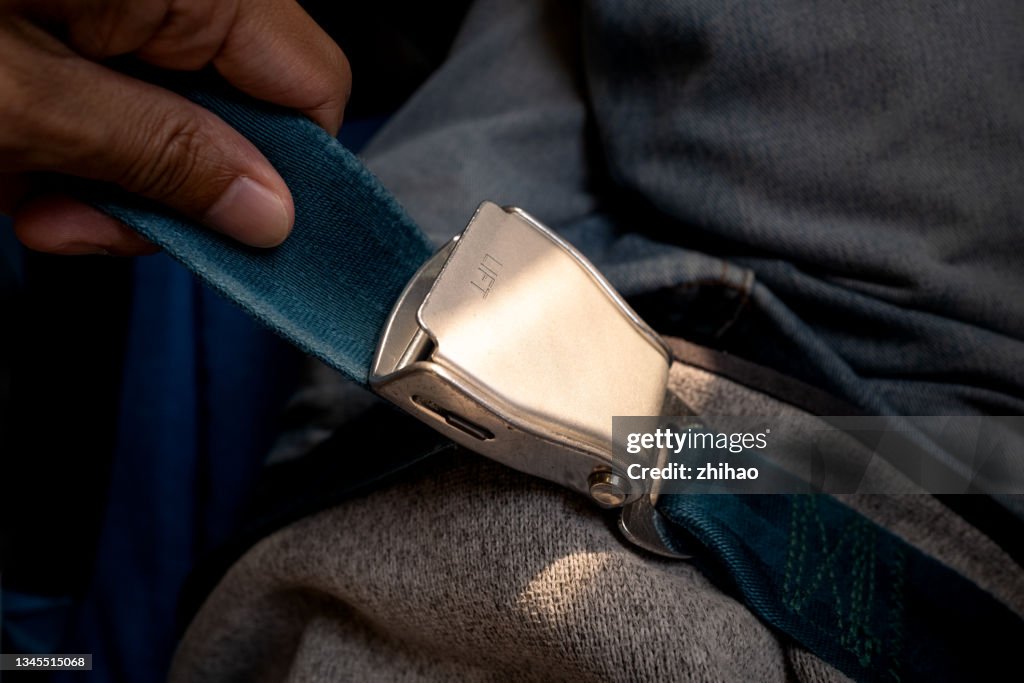 High angle view of passengers fixing seat belts on airplane seats