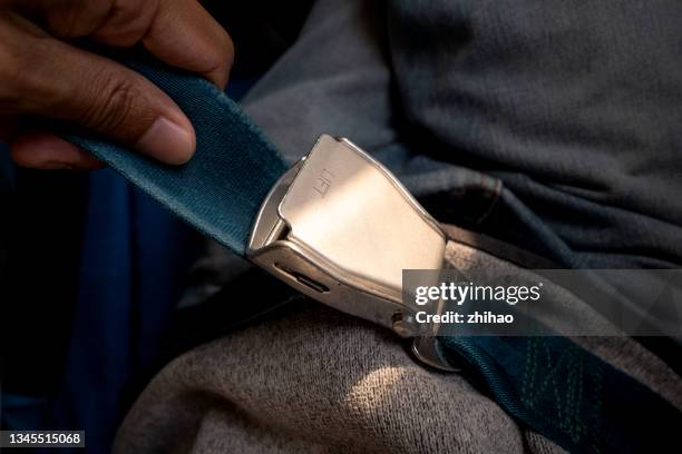 high angle view of passengers fixing seat belts on airplane seats - seatbelt stock pictures, royalty-free photos & images