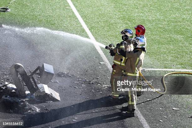 Firefighters attend an incident at the stadium after the pitchside VAR monitor catches fire at Estadi Nacional on October 08, 2021 in Andorra la...