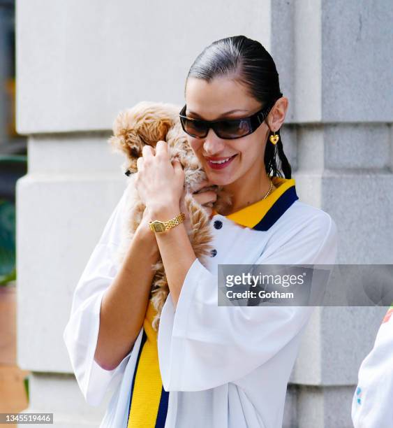 Bella Hadid plays with a dog on October 08, 2021 in New York City.