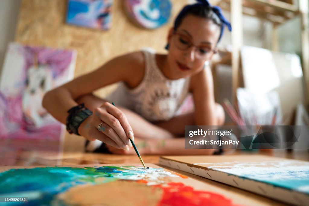 Creative female artist, making desire paint colors for her painting