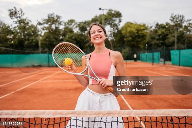 donna sorridente sul campo da tennis con palla e racchetta - gara sportiva individuale foto e immagini stock