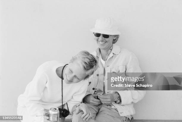 View of American actresses Anne Heche and Ellen DeGeneres, smiling, as they sit together, Los Angeles, California, 1996.