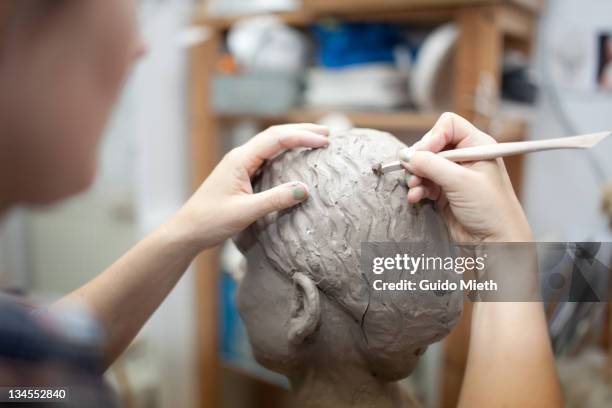 woman working on head sculpture - carving sculpture stock pictures, royalty-free photos & images