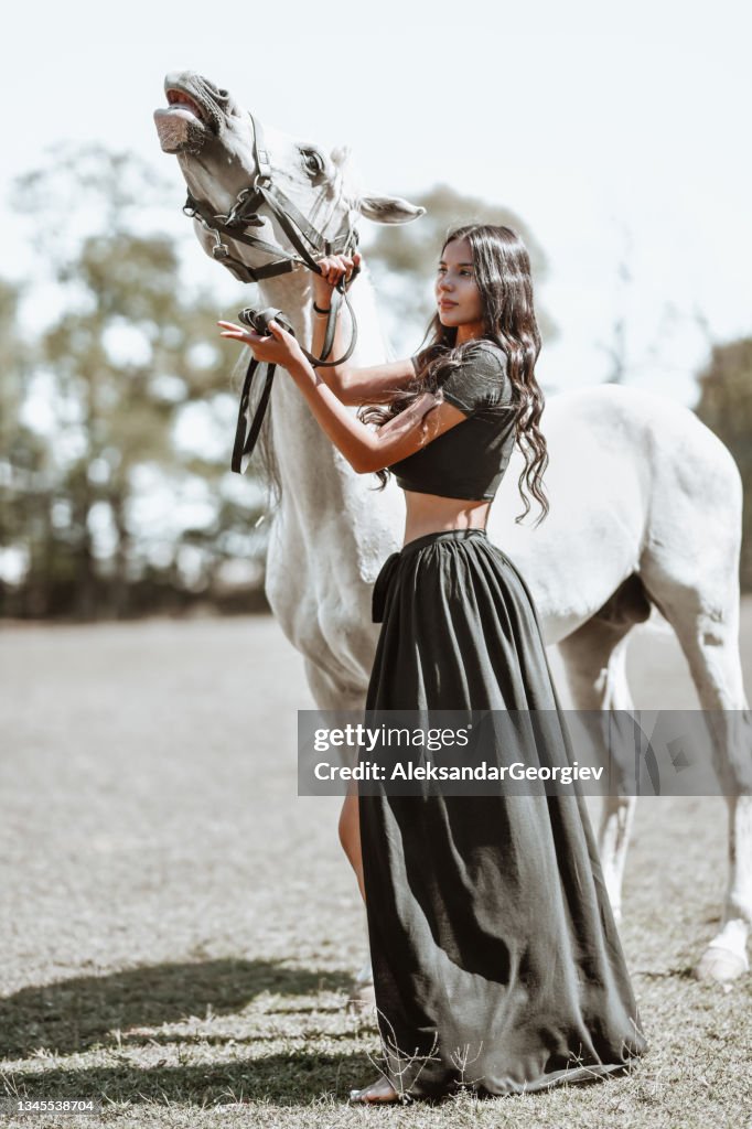 Beautiful Nomadic Gypsy Female Enjoying Time Spent With White Horse On Ranch
