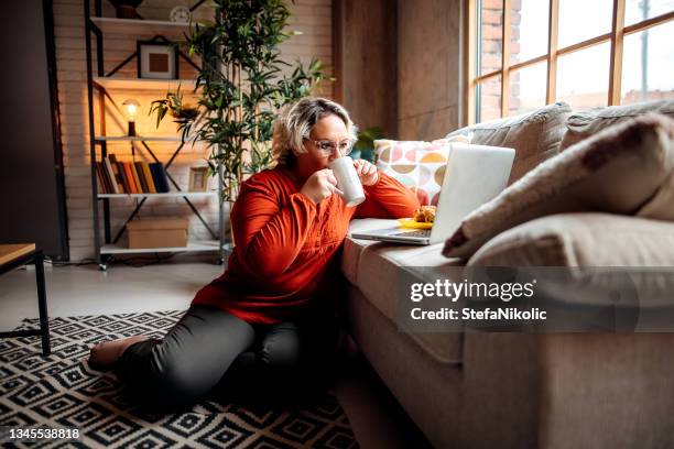 woman uses a laptop in her modern apartment - makeshift stock pictures, royalty-free photos & images