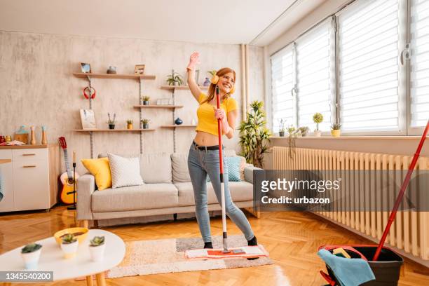 cheerfully woman cleaning house and singing - cleaning equipment stock pictures, royalty-free photos & images