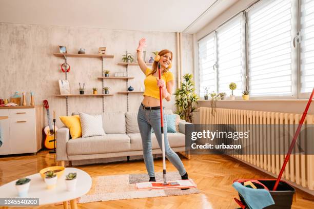 alegremente mulher limpando casa e cantando - mop - fotografias e filmes do acervo