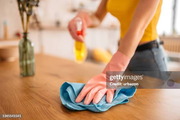 mujer limpiando la superficie de la mesa de comedor - home cleaning fotografías e imágenes de stock