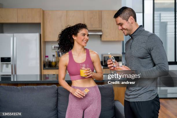 happy couple eating a healthy post-workout snack - nutrition coach stock pictures, royalty-free photos & images