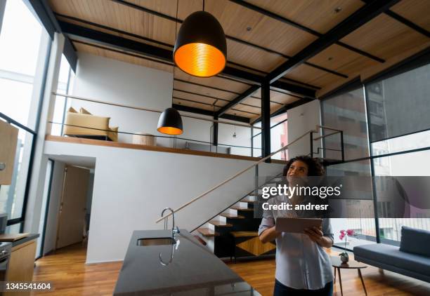 woman controlling the lights of her house using a home automation system - domotic bildbanksfoton och bilder