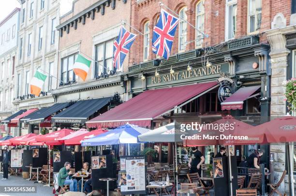 irish and english flags above st. alexandre pub - republic of ireland flag stock pictures, royalty-free photos & images