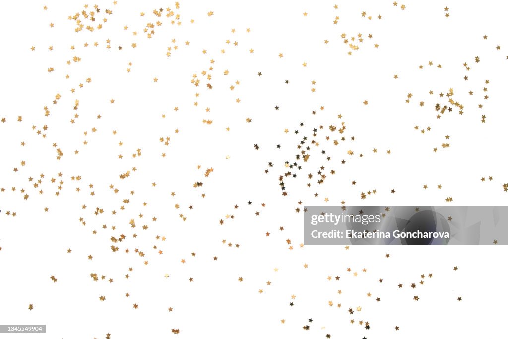Gold sparkling stars on a white isolated background.