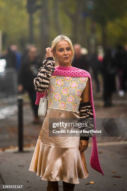 Guest wears gold earrings, a pink braided wool scarf from Miu Miu, a black and beige striped gloves, a pale gray embossed pattern leather shoulder...