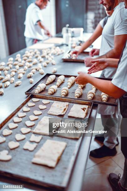 bakers making cookies and mini croissants in bakery - heart shape pizza stock pictures, royalty-free photos & images