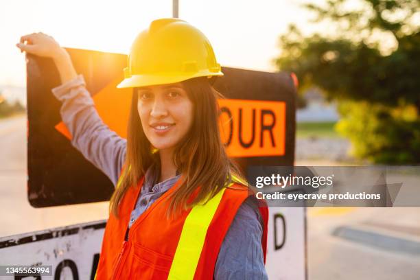 happy sun-saturated hispanic workers setting barriers and directing traffic street road and highway construction photo series - guarding building stock pictures, royalty-free photos & images