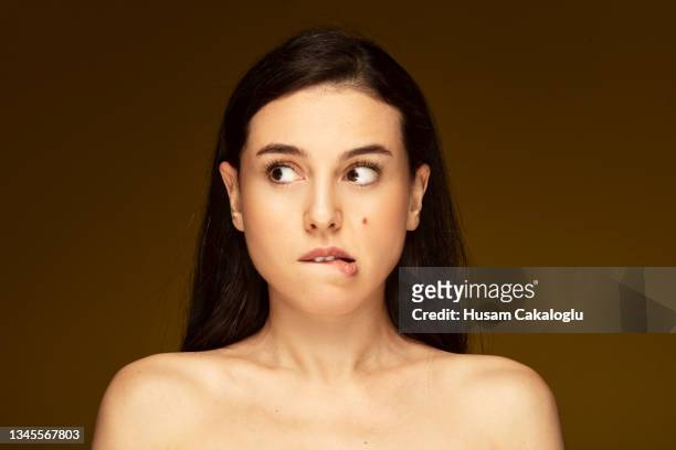 portrait of anxious woman with mole on her cheek, waiting anxiously. - biting lip stock pictures, royalty-free photos & images