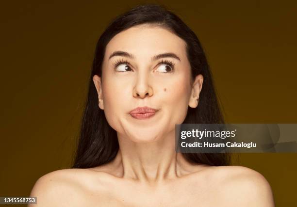 la femme coquine avec une taupe sur la joue regardant ce qui se passe à côté avec des yeux curieux. - mélanome photos et images de collection