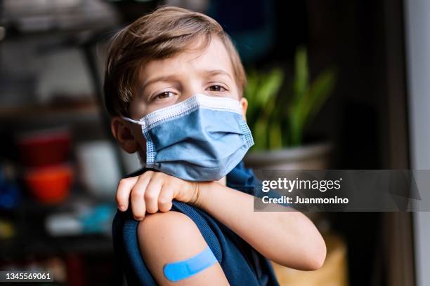 six years old child showing his band aid just after being vaccinated - 4 5 years stock pictures, royalty-free photos & images