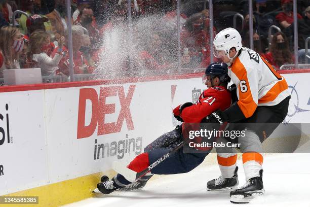 Travis Sanheim of the Philadelphia Flyers and of the Washington Capitals go after the puck in the second of a preseason game at Capital One Arena on...