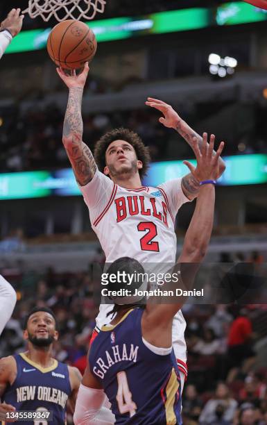 Lonzo Ball of the Chicago Bulls shoots over Devonte' Graham of the New Orleans Pelicans at the United Center on October 08, 2021 in Chicago,...