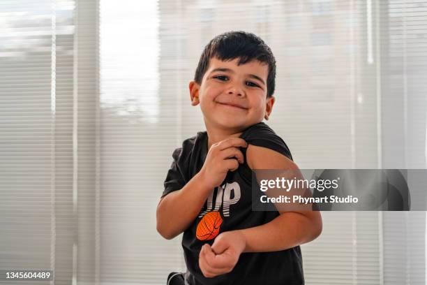 vaccinated child showing shoulder after shot - arab student kids stock pictures, royalty-free photos & images