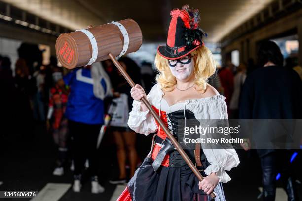Cosplayer dressed as a mashup between Harley Quinn and The Queen of Hearts form "Alice in Wonderland" poses during the second day of Comic Con at...